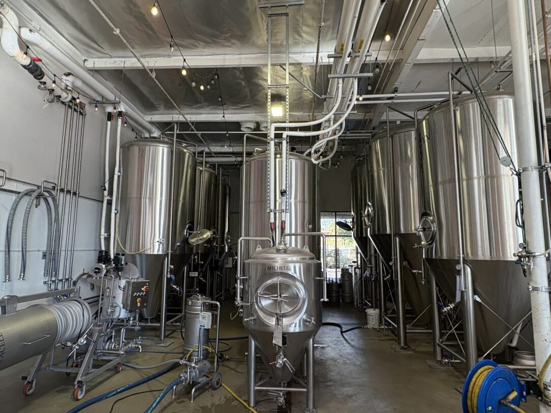 Craft brewery production floor with stainless steel fermentation tanks