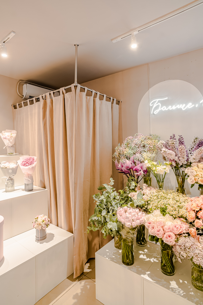 Flower shop with track lighting system illuminating retail floral displays