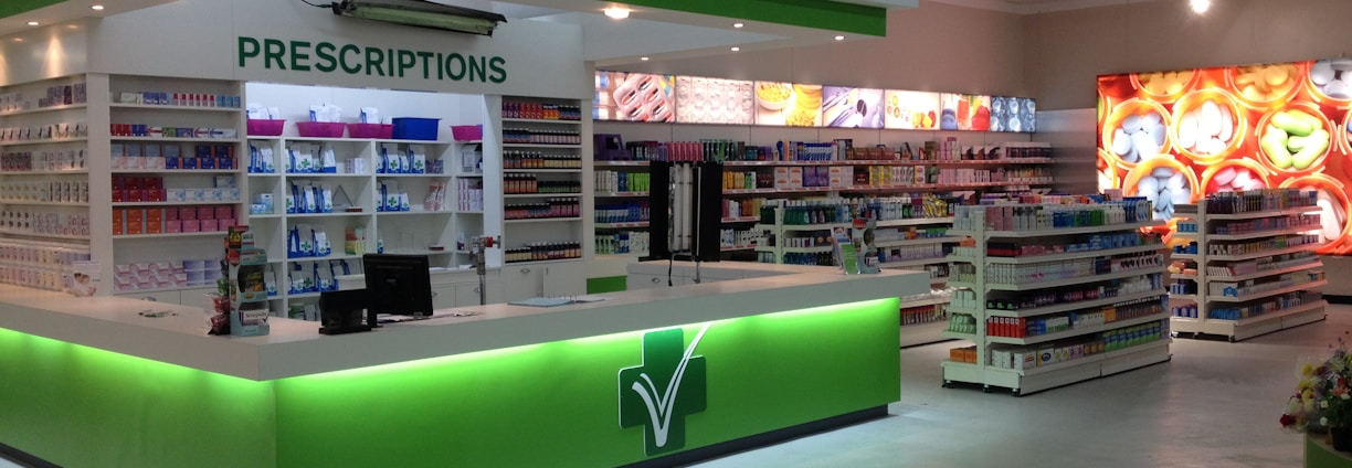 Pharmacy prescription counter with organized shelving and professional lighting