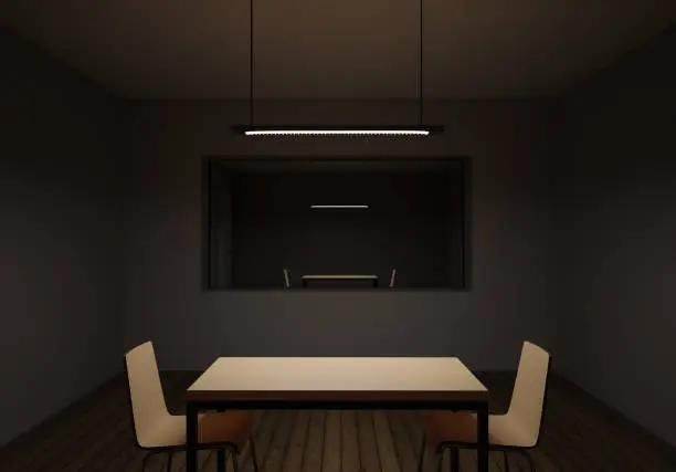 Police interview room with dark gray walls and ceiling, a long rectangular pendant light fixture hanging above a white rectangular table, two white cushioned chairs on opposite sides of the table, a small recessed area in the back wall leading to another room with similar furniture, creating a stark minimalist environment with focused overhead lighting